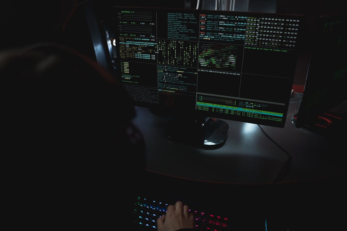 Security analyst reviewing multiple threat-monitoring screens in a cyber operations setting.