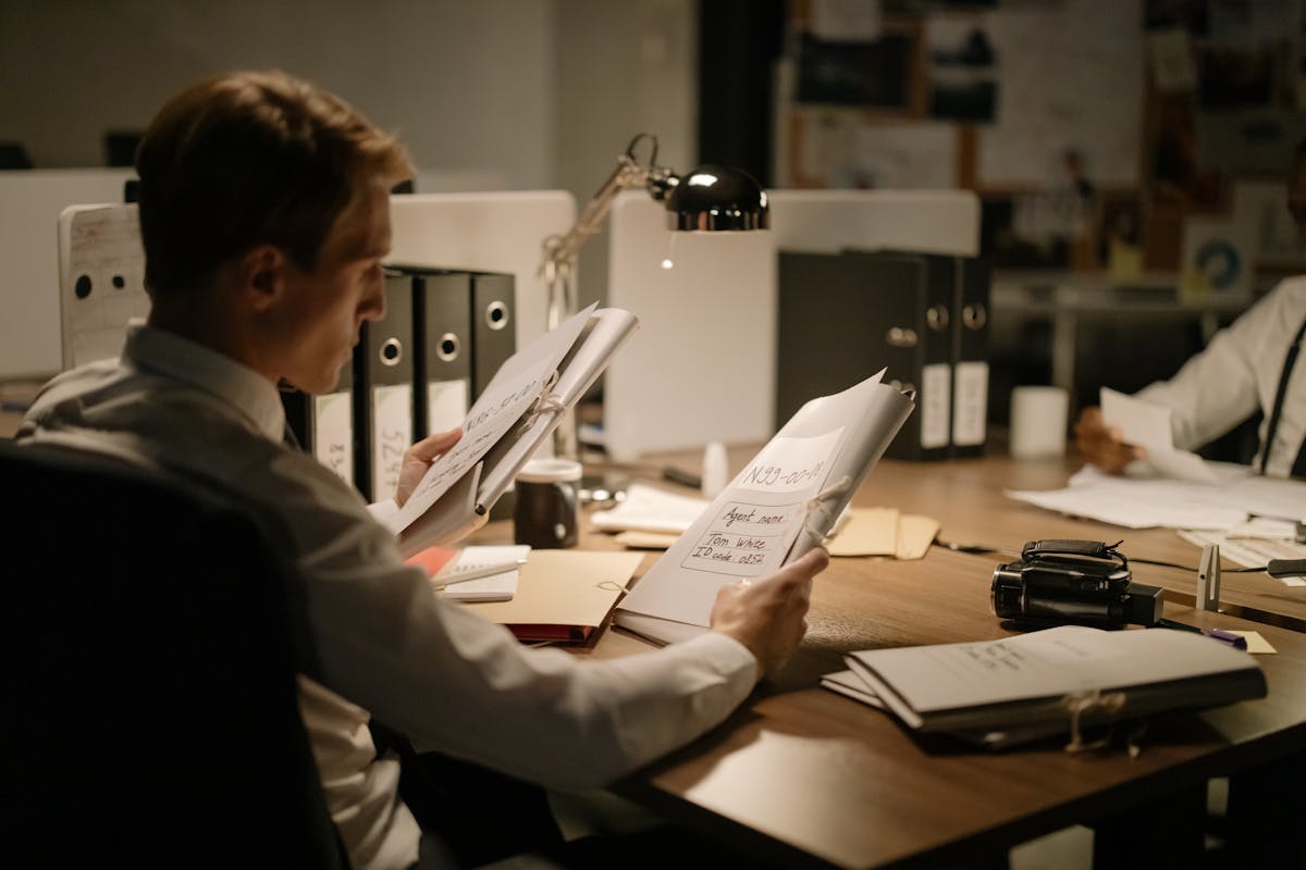 Investigator analyzing documents and digital evidence during an OSINT review.